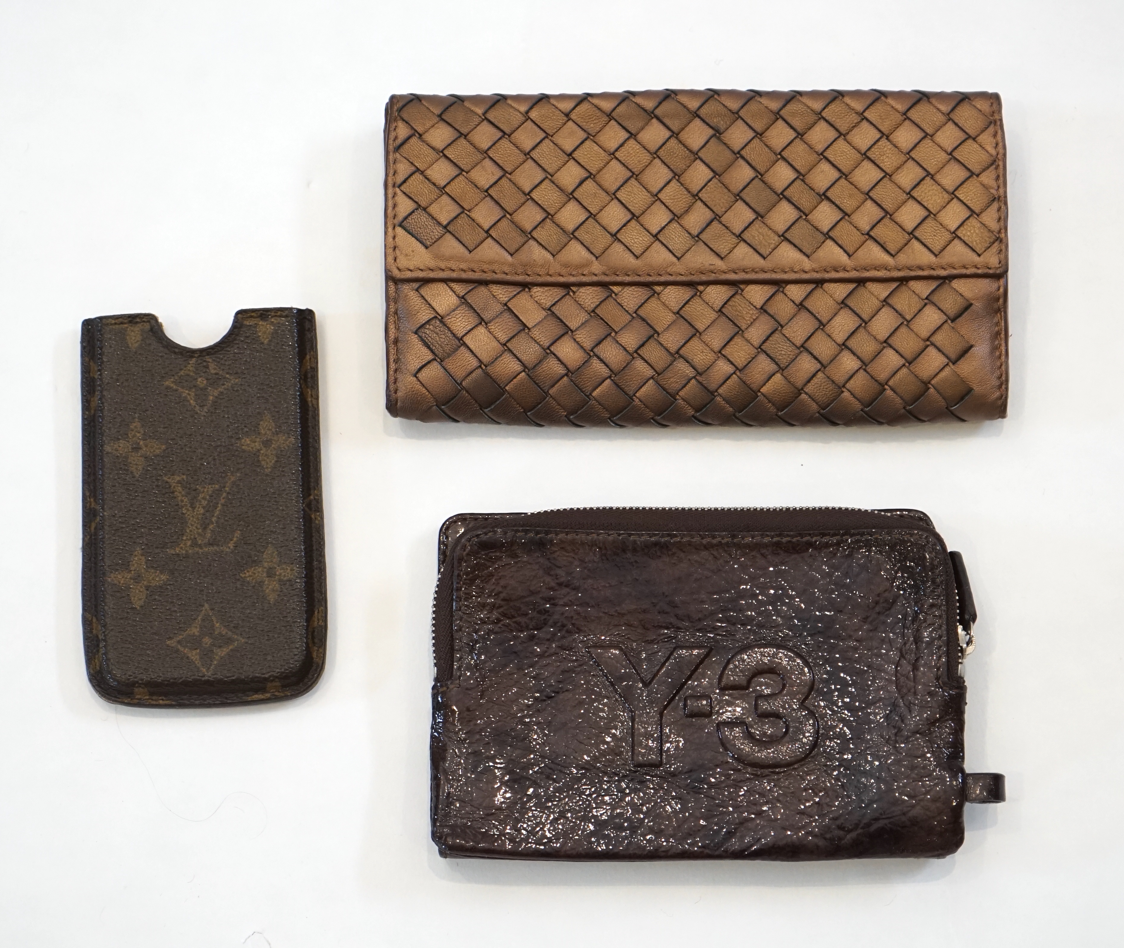 A Bottega Veneta purse, a Y-3 purse/wallet and a Louis Vuitton phone case